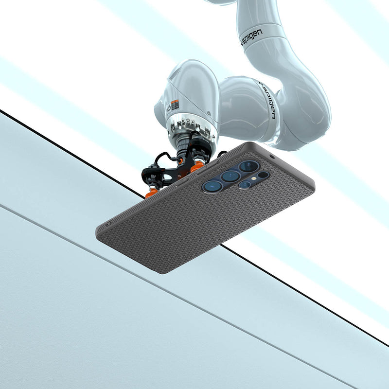 ACS08954 - Galaxy S25 Ultra Case Liquid Air in Marble Gray showing the robotic arm holding the device in an elevated horizontal position, angled slightly upward. Showing the device back facing outward, revealing its camera module. The robotic arm is positioned above a clean, structured background with defined panels