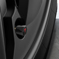 ACP11370 - Universal Tire Valve Stem Cap | VS100TS/R in silver installed on a wheel, featuring a faceted hexagonal design with a red Tesla logo accent.