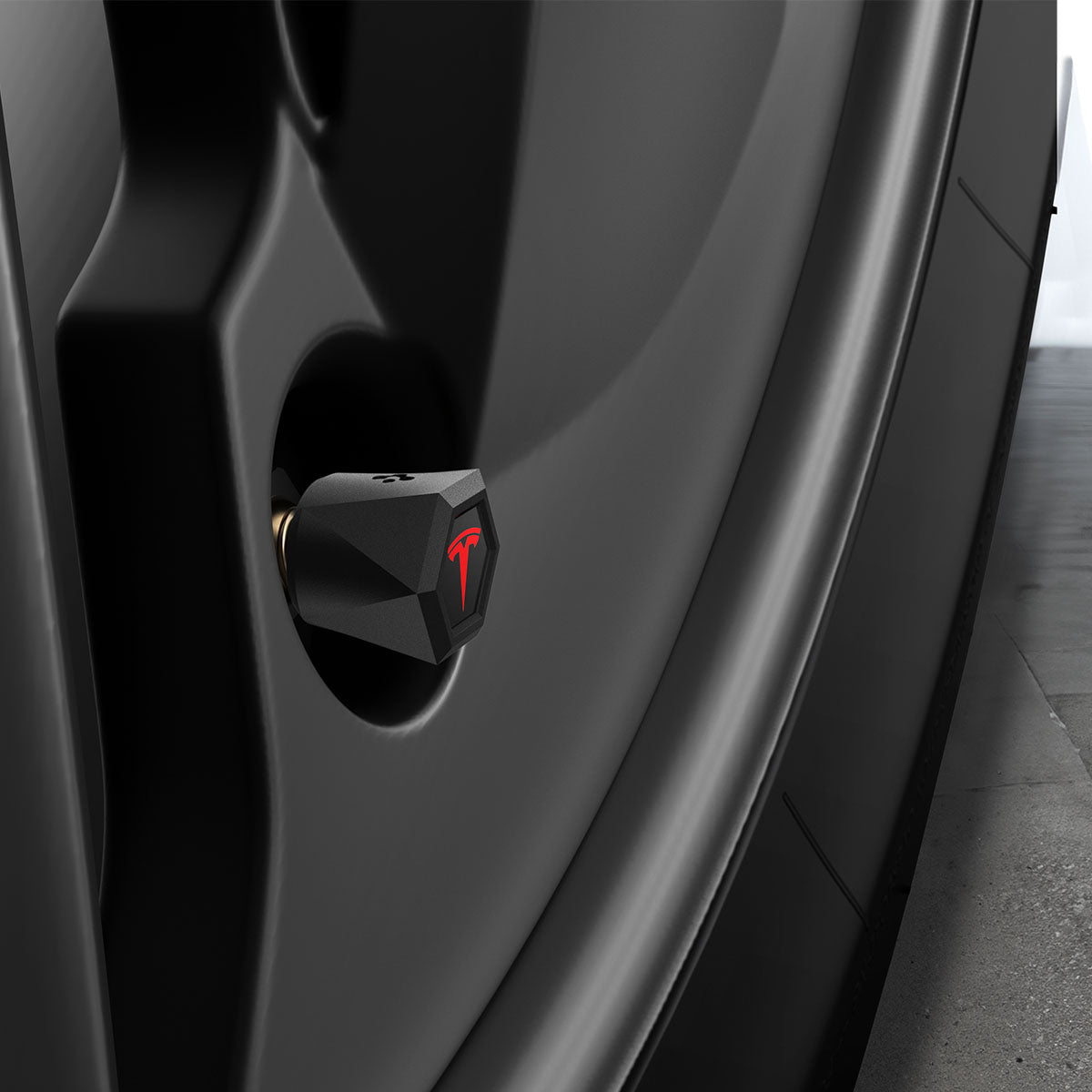 ACP11370 - Universal Tire Valve Stem Cap | VS100TS/R in silver installed on a wheel, featuring a faceted hexagonal design with a red Tesla logo accent.